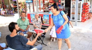 Çöpte bulduğu bayrakları temizleyip esnafa dağıttı