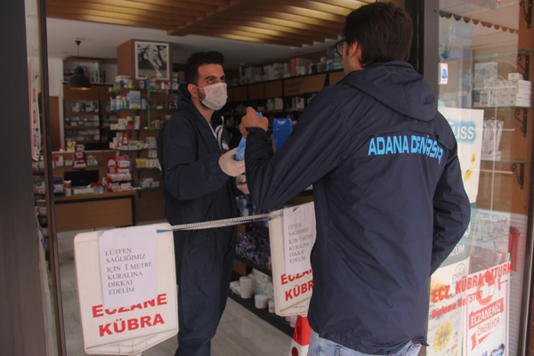 Eczanede özel kıyafetli ve güvenlik şeritli korona önlemi