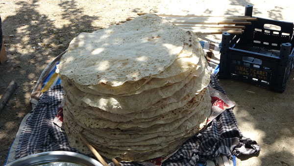 Odun ateşinde imece usulü ekmek yapıyor