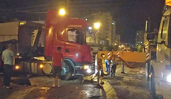 Yolda oluşan çukura düşen tır, çekiciyle kurtarıldı